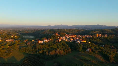 Warm Evening Light Over Small Countryside Settlement and Forested Hills Stock Footage 347756426