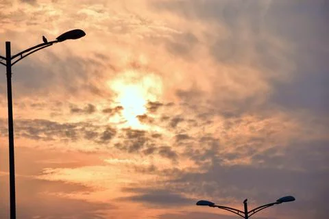 Warm evening sun glowing through dramatic clouds Stock Photos