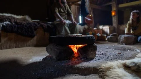 Warm fire glows beneath a stone hearth Stock Photos