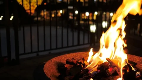 Warm flames with ice skaters in the background at a ski resort. Video stock 85333578