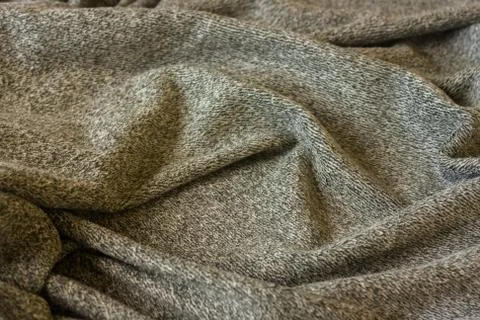 Warm fluffy grey blanket. Texture of material with folds. Stock Photos