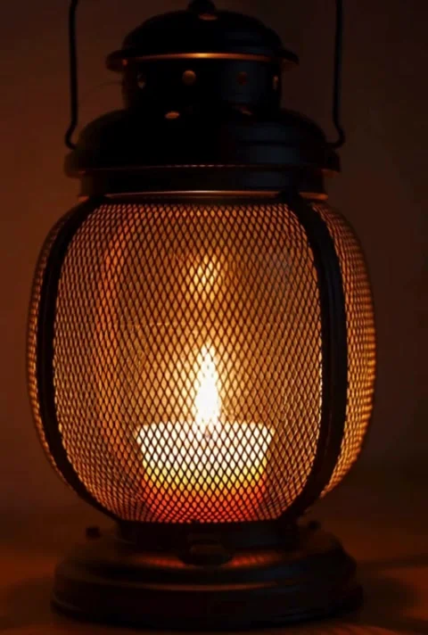 Warm glow of candle flame flickering inside metal lantern creating cozy atm.. Stock-Footage 320591262