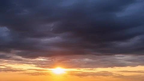 The warm glow of the down sun on a dramatic cloudy sky is a beautiful sight to Stock Photos
