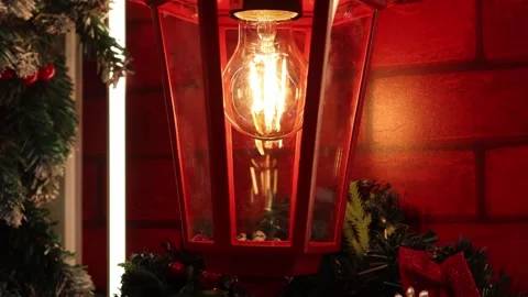Warm glow of a festive lantern illuminating winter magic in cozy surroundings 스톡 동영상 296145170