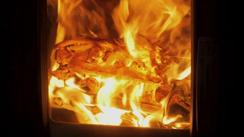 Warm glow of a fireplace illuminating burning logs in a cozy setting at night Stock Footage 314151322