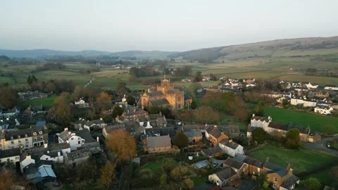 Warm golden light bathes quiet village at dawn Stock Footage 345650579