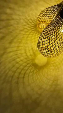 Warm golden string lights with a beautiful metallic mesh texture creating a.. Stock Photos