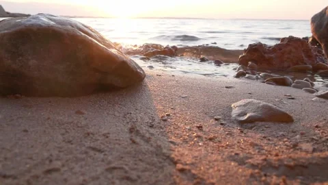 Warm golden sunset glows softly over a rocky ocean beach. Stock Footage 337406862