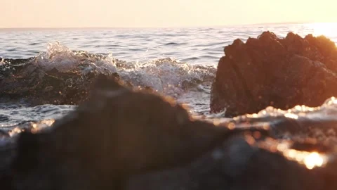 Warm golden sunset light glowing over ocean coastal rocky waves Stock Footage 337409281