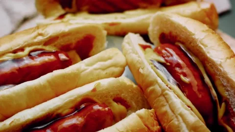 Warm hands arranging sausages inside split rolls in tight shot, 4K Video stock 341116850