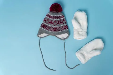 Warm hat and mittens on light blue background for winter season Stock Photos
