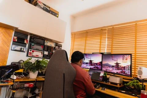 Warm home workspace with blurred computer monitors. Stock Photos