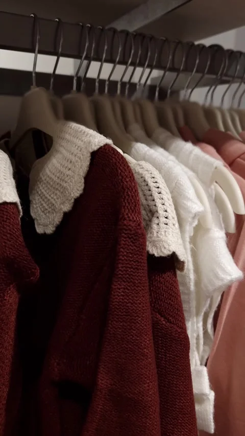 Warm Knitted Sweaters with Lace Collars Hanging in a Row Stock Footage 326061357
