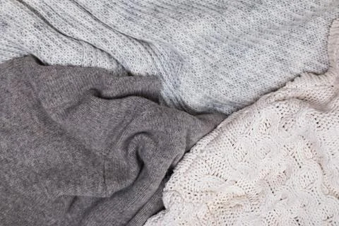 Warm knitted sweaters lying close, top view. Stock Photos