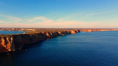 Warm light on coastal cliffs and wind farm at dusk, Bulgaria Stock Footage 336726786