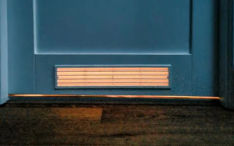 Warm Light Emanating From Underneath A Door With Slatted Vent Stock Photos