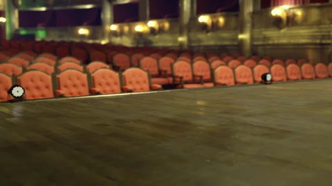 Warm lighting illuminates intimate performance setting with plush chairs Stock Footage 343617588