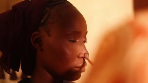 Warm Lighting on Woman's Face During Make-up Application Session Stock Footage 332735492