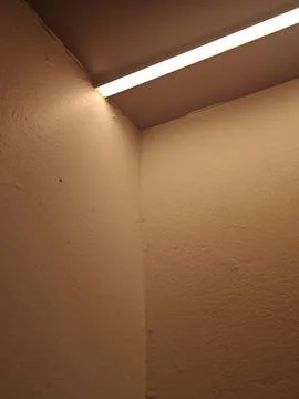 Warm Linear LED Lighting in Interior Corner with Textured Walls Stock Photos