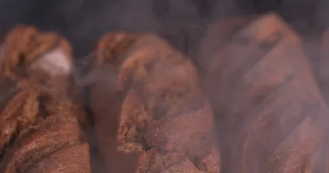 Warm loaf in a row lies on a table in smoke on a black background  Stock Footage 130361821