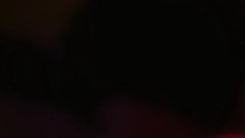 Warm magenta and deep red lens flare glows softly on a dark background Stock Footage 342216903