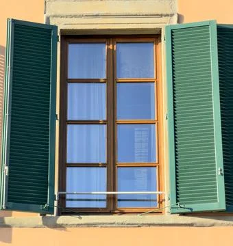 Warm Mediterranean Setting Features Open Shutters Reflecting Blue Sky Stock Photos