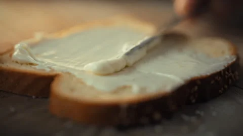 In a warm morning kitchen deft hands skillfully spread a rich cheese blend o Vidéo 331353230