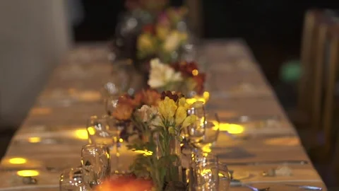 Warm moving lights illuminate an elegantly decorated wedding reception table Stock Footage 321080873