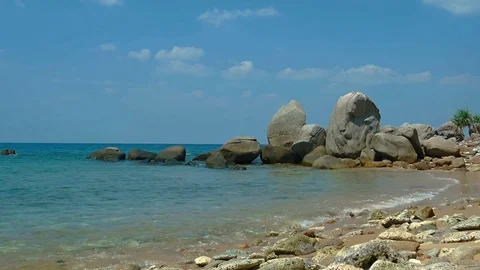Warm Ocean Water Laps at Boulder Strewn Tropical Beach Vidéo 74964058