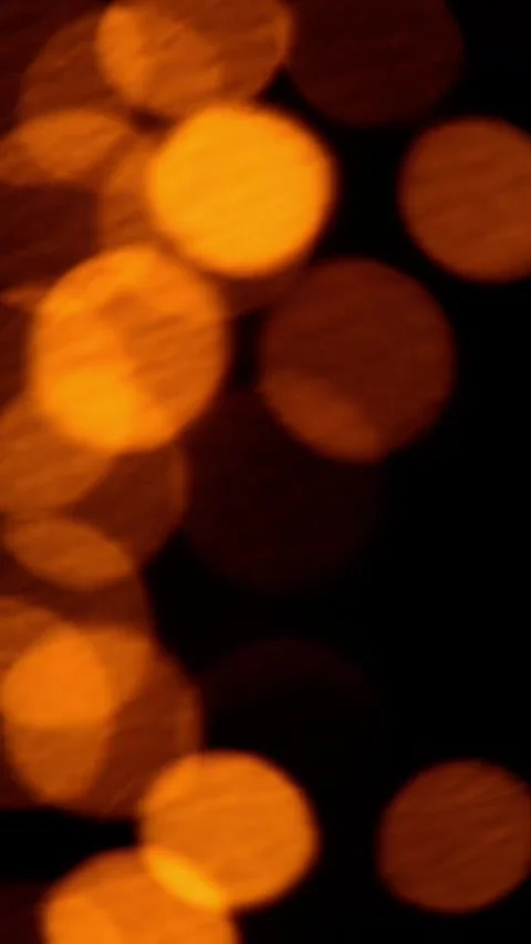Warm orange bokeh light leaks drifting on dark background Stock Footage 325711688