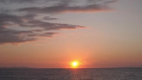 Warm peaceful sunset glows softly beneath colorful clouds over horizon. Stock Footage 337414288