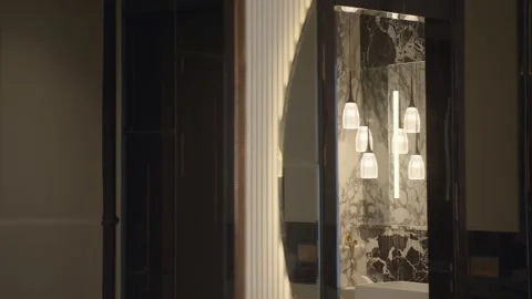 Warm pendant lights and black and white marble sink reflected in circular Stock Footage 328482680