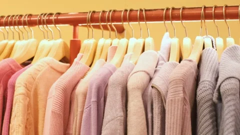 Warm pink knit sweaters hang on hangers in the store close-up. Stock Footage 254638848