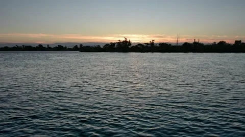 Warm river sunset and gentle waves with birds flying on background Stock Footage 155200196