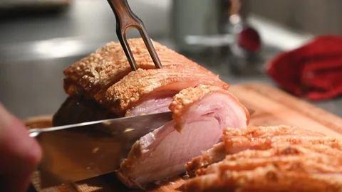 Warm roast pork gets cut in slices with kitchen knife Stock Footage 116249921