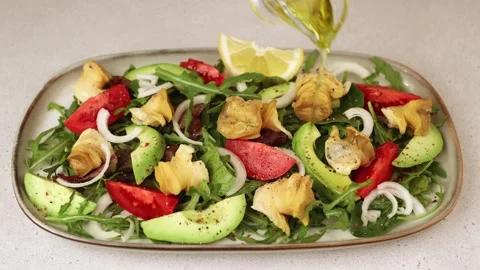 Warm salad with rapan, tomatoes, avocado, onions, leafy vegetables, lemon. Stock Footage 258247647