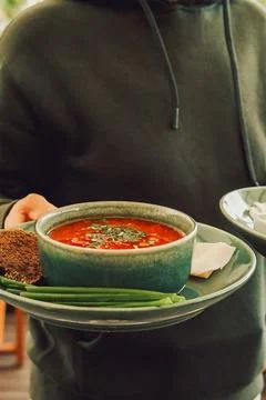 Warm soup served with bread and green onions at  casual dining setting during Stock Photos
