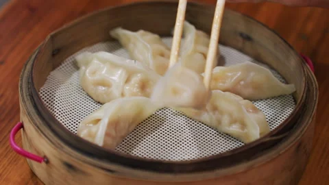 Warm steam ascends above freshly prepared traditional dumplings displayed Stock Footage 342279913