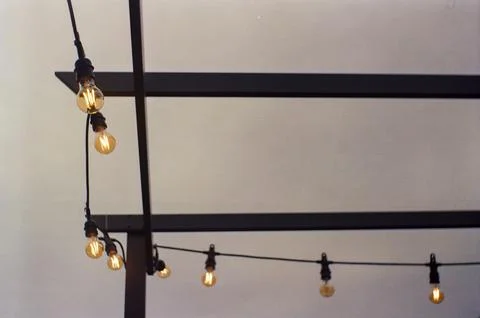 Warm String Lights Against an Overcast Sky Stock Photos