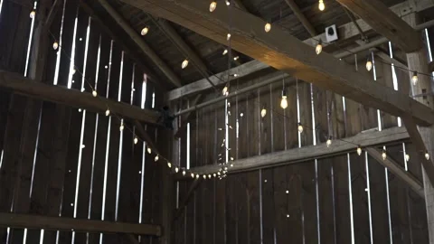 Warm string lights beautifully enhance the charm of a cozy wooden barn Stock Footage 304985230