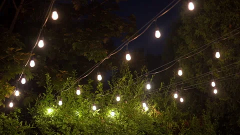 Warm string lights glowing against the night sky outside a event venue. Elegant Stockbeeldmateriaal 346791326