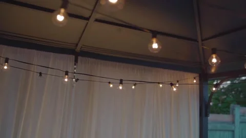 Warm String Lights Illuminating Outdoor Gazebo at Dusk Romantic Ambiance. Stock Footage 313318638