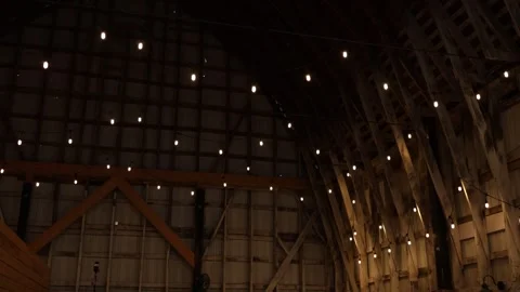 Warm string lights in rustic barn interior Stock Footage 338035072