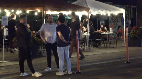 Warm summer night with people walking and restaurant patios open in new normal 動画素材 155578826