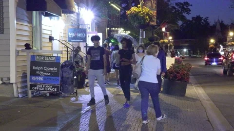 Warm summer night with people walking and restaurant patios open in new normal Stock-Footage 155580237