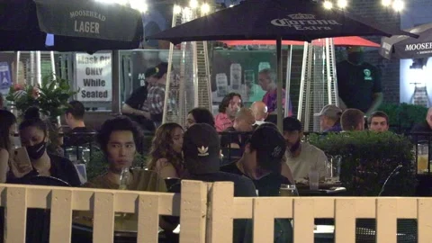 Warm summer night with people walking and restaurant patios open in new normal 動画素材 155583809