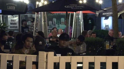 Warm summer night with people walking and restaurant patios open in new normal 動画素材 155583938