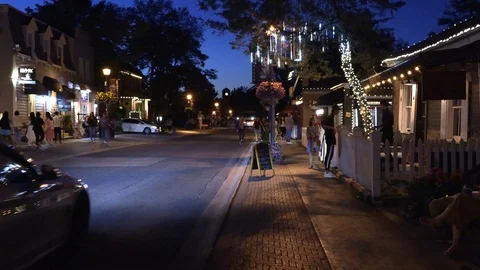 Warm summer night on small town main street with people out walking Stock Footage 111572002