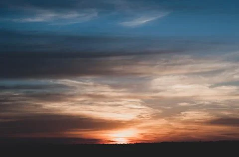 Warm sun rays reflected in clouds. Gloomy blue sky with dark clouds above set Stock Photos