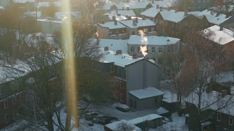 Warm Sunbeam Cuts Through A Snowy Riga Neighborhood As Chimney Smoke Rises Above Stock Footage 346266454